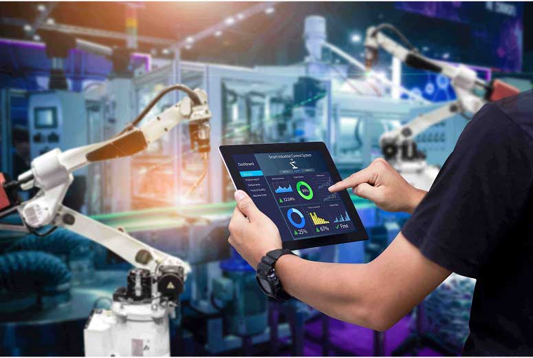 Person using a tablet to control robotic arms in a smart factory.