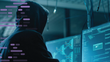 Hacker in hoodie at computer