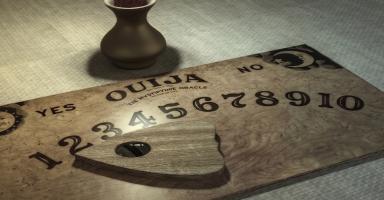 Ouija board with planchette pointing to numbers, dark vase in background.