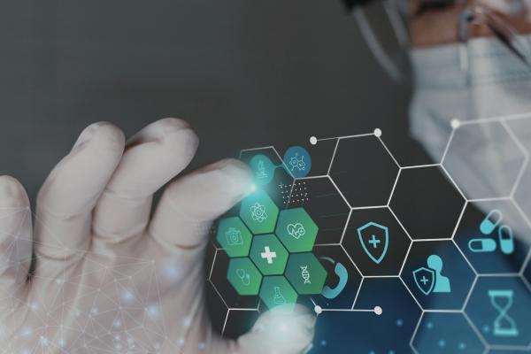 Gloved hand touching a digital screen with glowing green hexagonal medical icons.